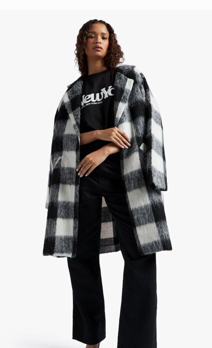 Trendy New York T-Shirt in black, styled with a plaid coat.