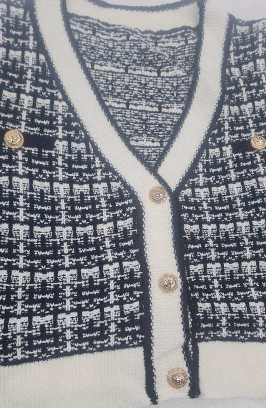 Women's plaid cardigan with contrast trim and button decor.