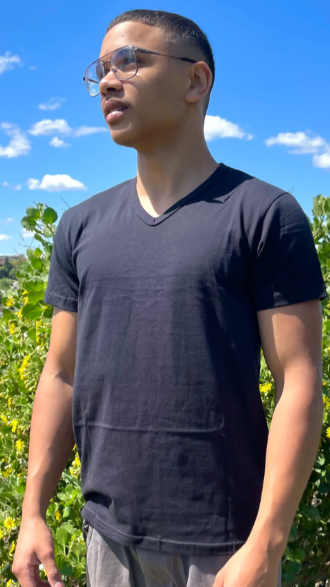 Unisex V-neck black cotton T-shirt worn outdoors.