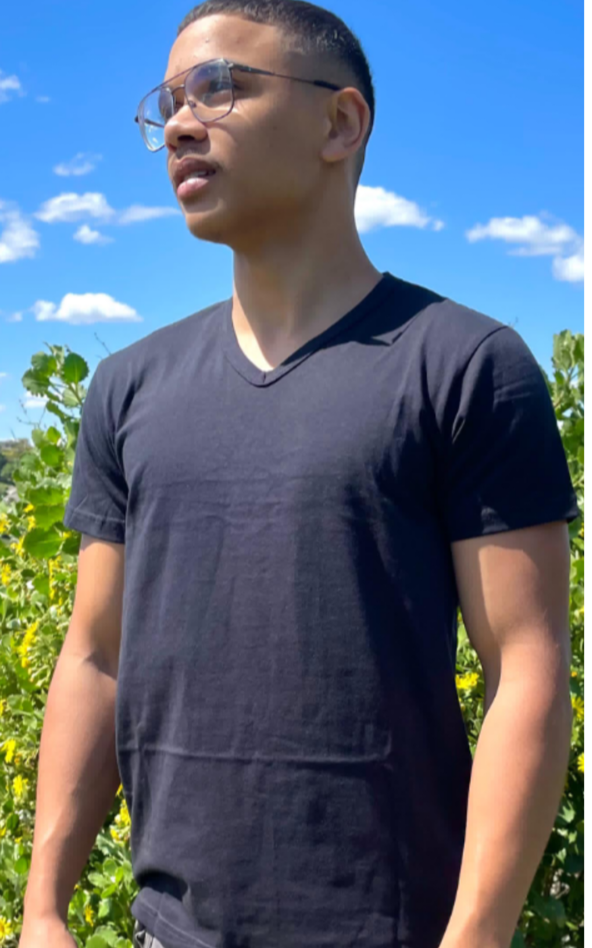 Unisex black V-neck cotton T-shirt, semi-fitted style, outdoor background.