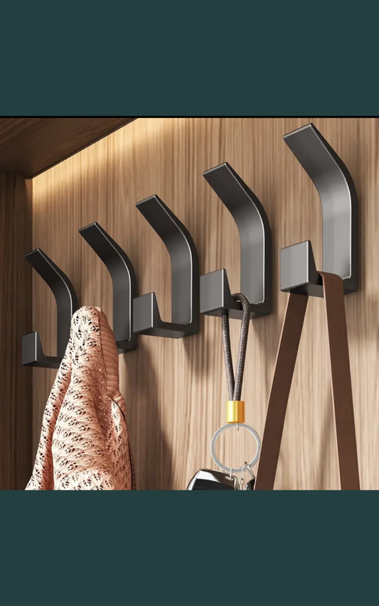 Set of 5 black punch free hooks mounted on wooden wall for hanging clothes and accessories