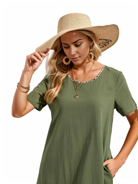 Woman wearing green floral binding dress with round neck and short sleeves, accessorized with large hat and jewelry